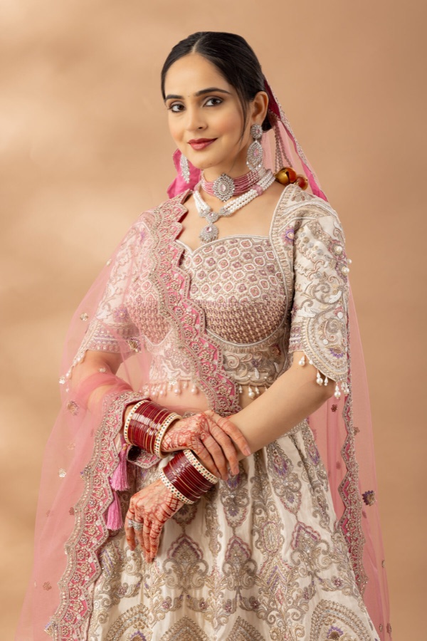 Pink lehenga with hand embroidery, seated pose