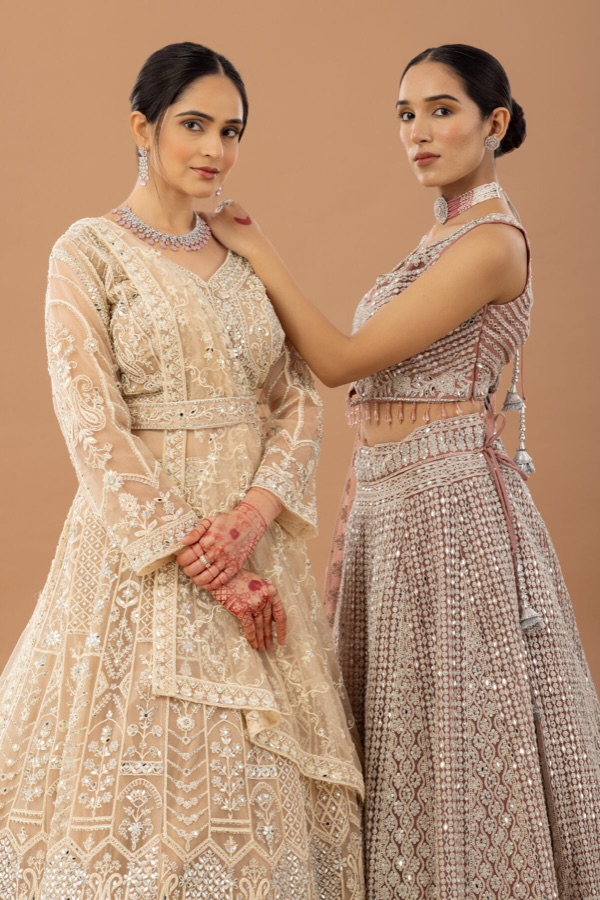 Two models in cream and grey lace lehengas