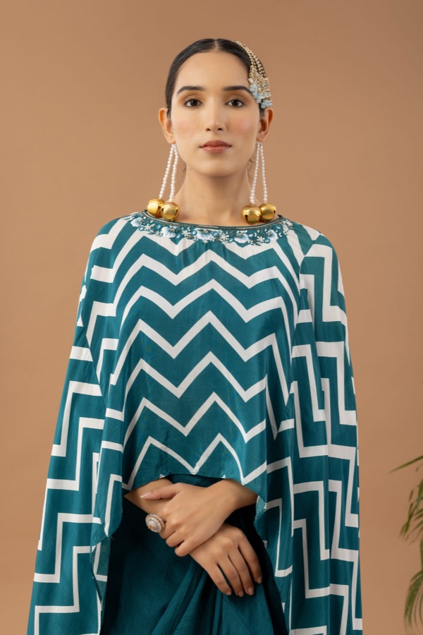 Teal chevron-print cape with statement earrings